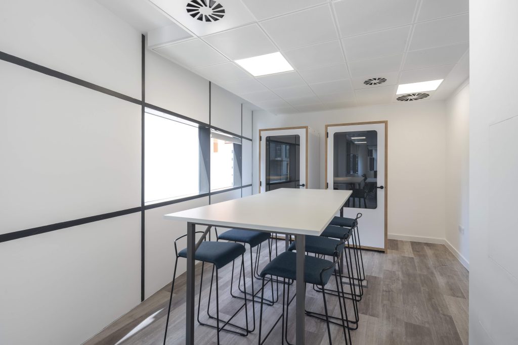 Newly refurbished office space in The Poppy Building, located in Brewhouse Yard, London's Tech Hub, featuring floor-to-ceiling windows and a communal roof terrace.
